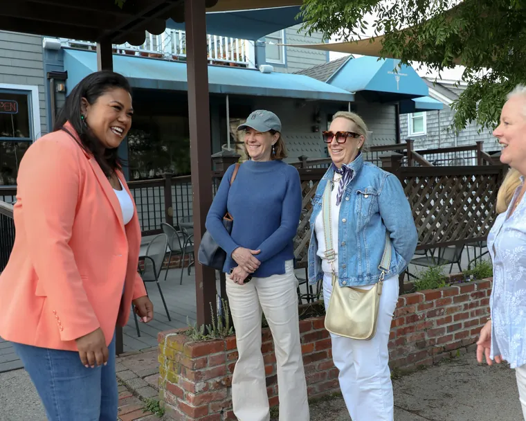 Angela Lima talking with a group of Newport residents on a sidewalk