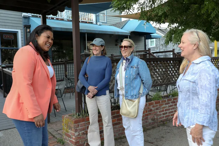 Angela Lima talking with residents on a Newport sidewalk
