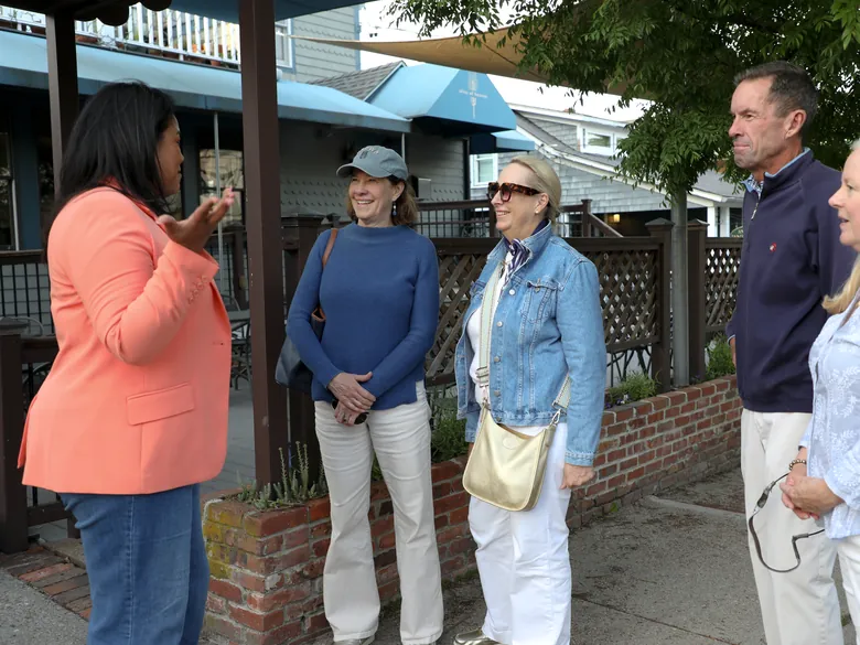 Angela Lima listening to a group of residents outside a Newport storefront